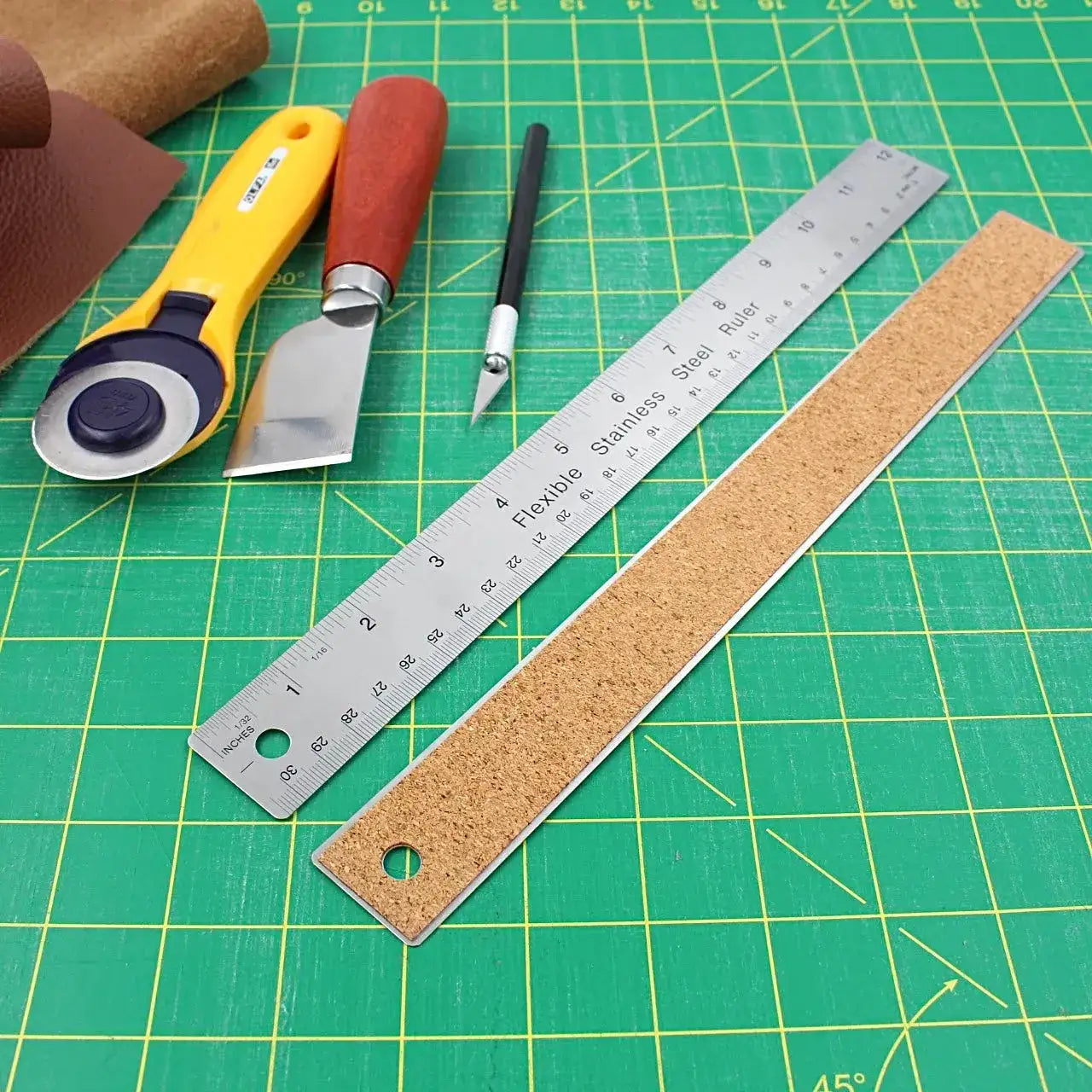Lederwerkzeuge Set mit Rollschneider, Cutter, Lineal und Lederstück auf Schneidmatte