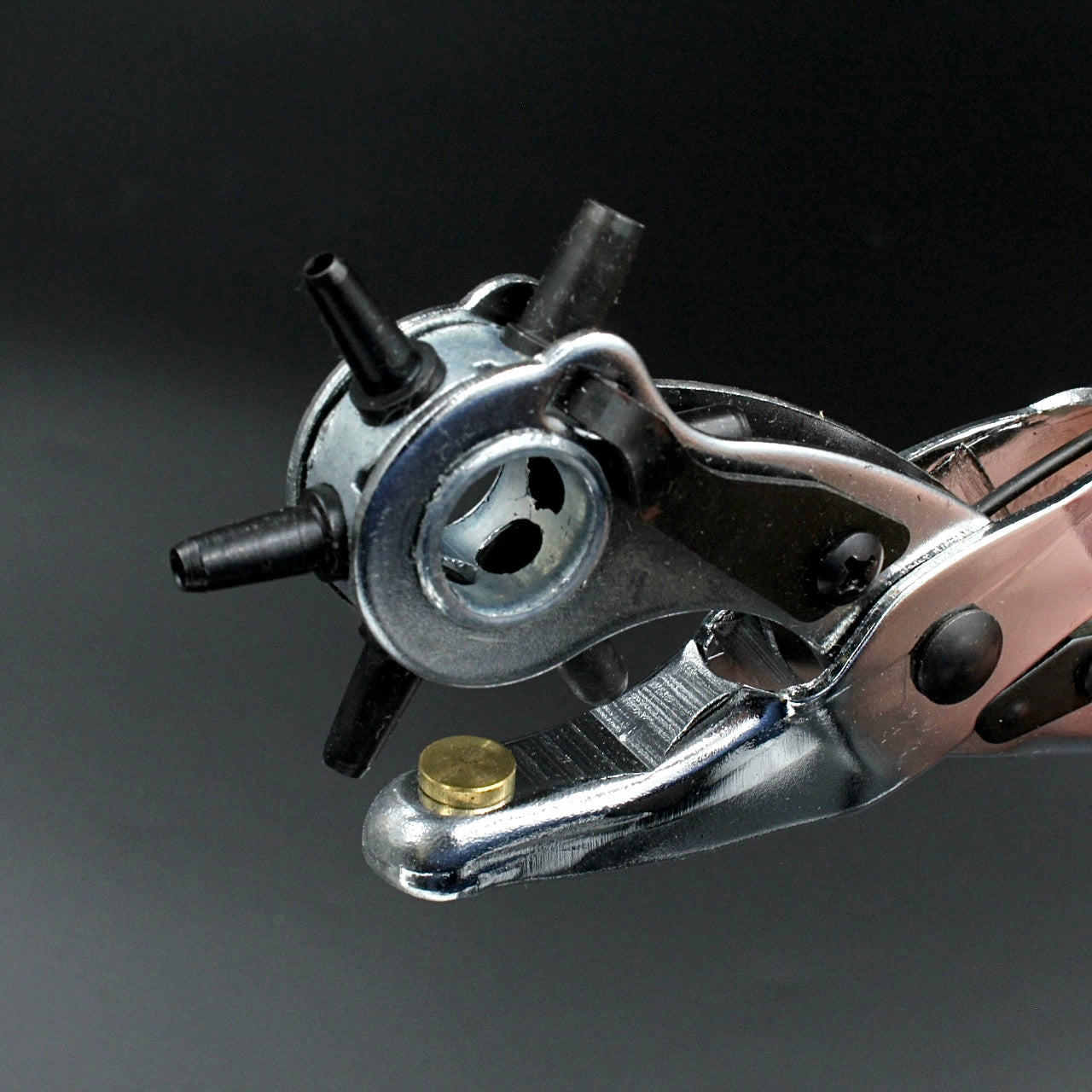 Nahaufnahme einer Lochzange für Lederarbeiten auf dunklem Hintergrund