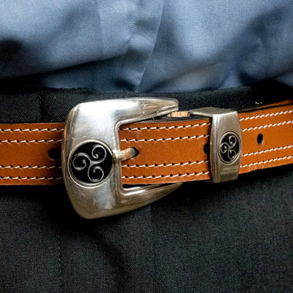 Brauner Ledergürtel mit silberner Schnalle und schwarzem Ziermotiv, close-up Ansicht