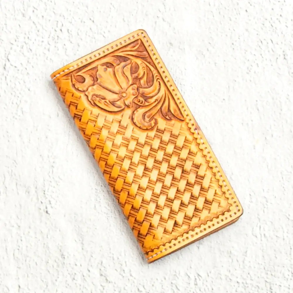Handgefertigte braune Leder-Geldbörse mit geprägtem Blumenmuster auf hellem Hintergrund