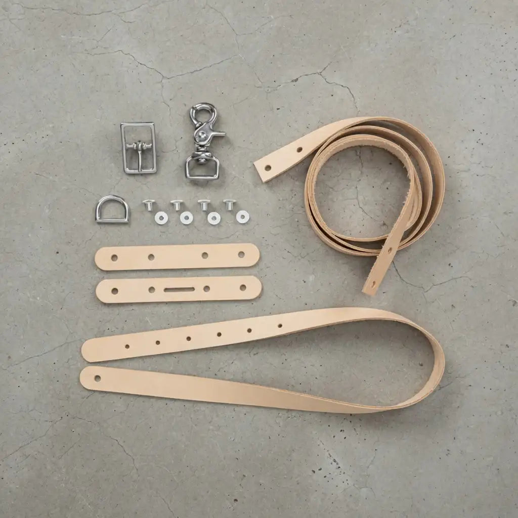 DIY Set: naturfarbene Lederstreifen, Metallteile und Werkzeuge für Lederhandwerk auf Beton