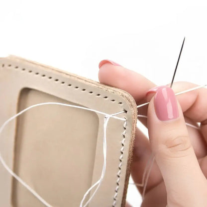 Hand näht helles Leder mit Nadel und weißem Faden, Nahaufnahme Handarbeit