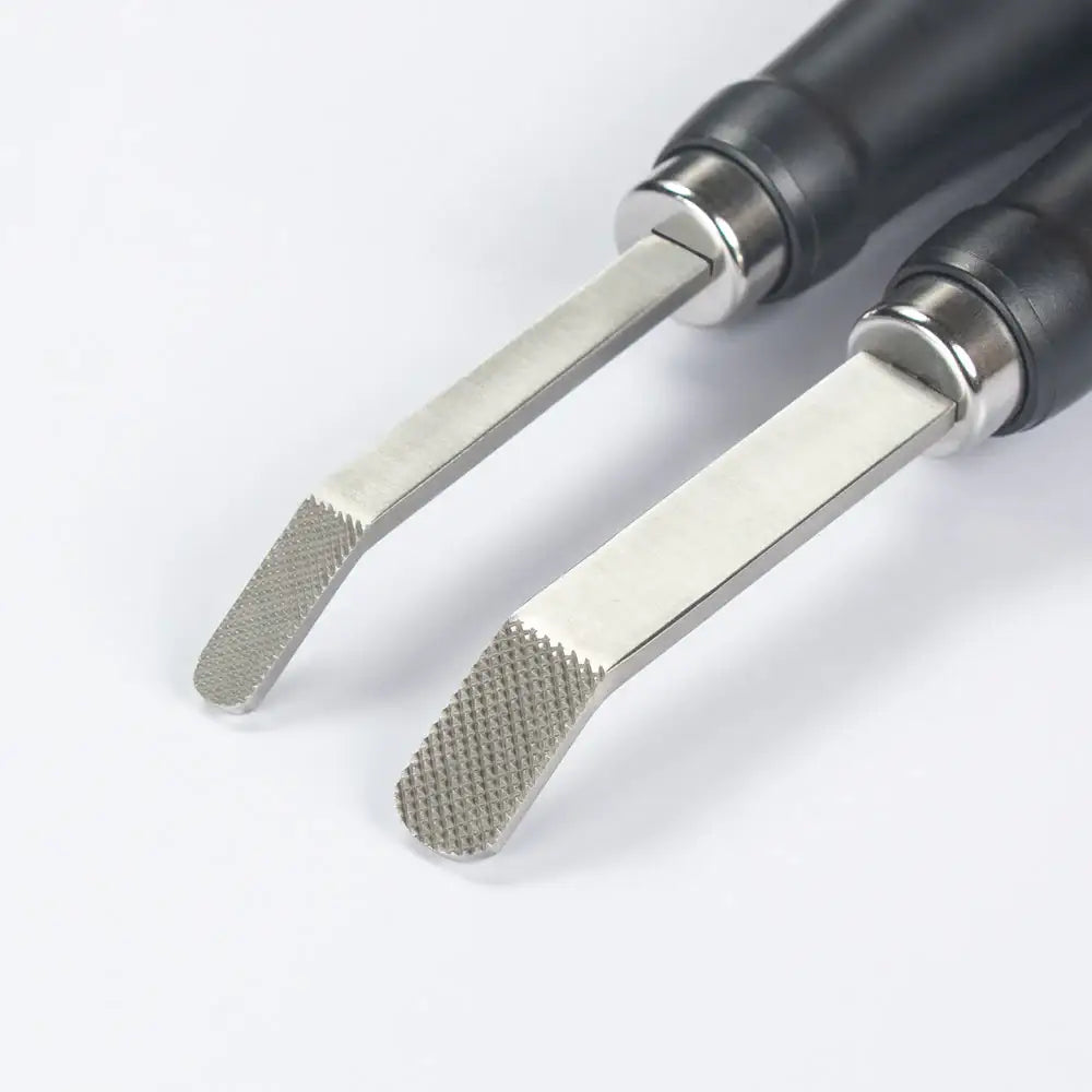 Zwei Lederwerkzeuge mit geprägter Metallspitze und schwarzem Griff auf weißem Hintergrund