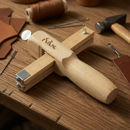 Lederwerkzeug aus Holz, auf Holztisch mit Leder, Faden und Werkzeugen für Lederhandwerk