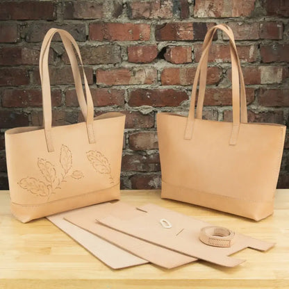 Naturfarbene Lederhandtaschen und DIY-Tasche-Näher-Set auf Holztisch vor Backsteinwand
