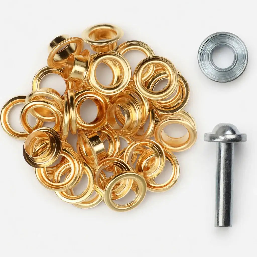 Goldene Ösen mit Metallwerkzeug für Lederarbeiten auf weißem Hintergrund