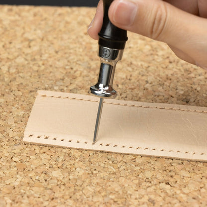 Lederlochstanzwerkzeug beim Prägen von Löchern in hellem Leder für Handwerker & Bastler