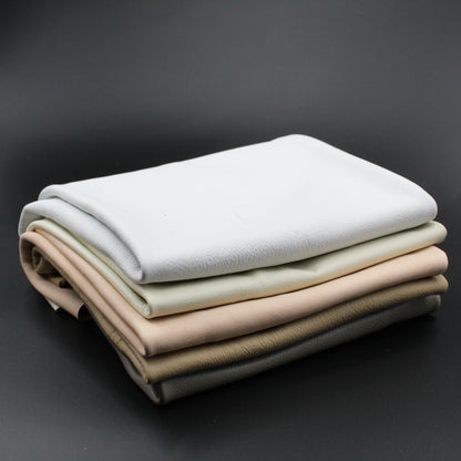 Gefaltete Lederstücke in verschiedenen Naturtönen auf schwarzem Hintergrund, ideal für Lederprojekte