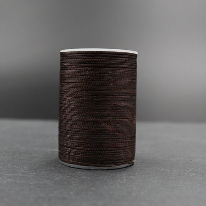 Dunkelbraunes Nähgarn auf Spule, ideal für Lederarbeiten und Bastelprojekte bei Klever Leder