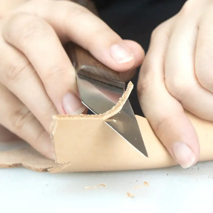 Hand schneidet Naturleder mit scharfem Werkzeug, Detail Handarbeit Lederverarbeitung