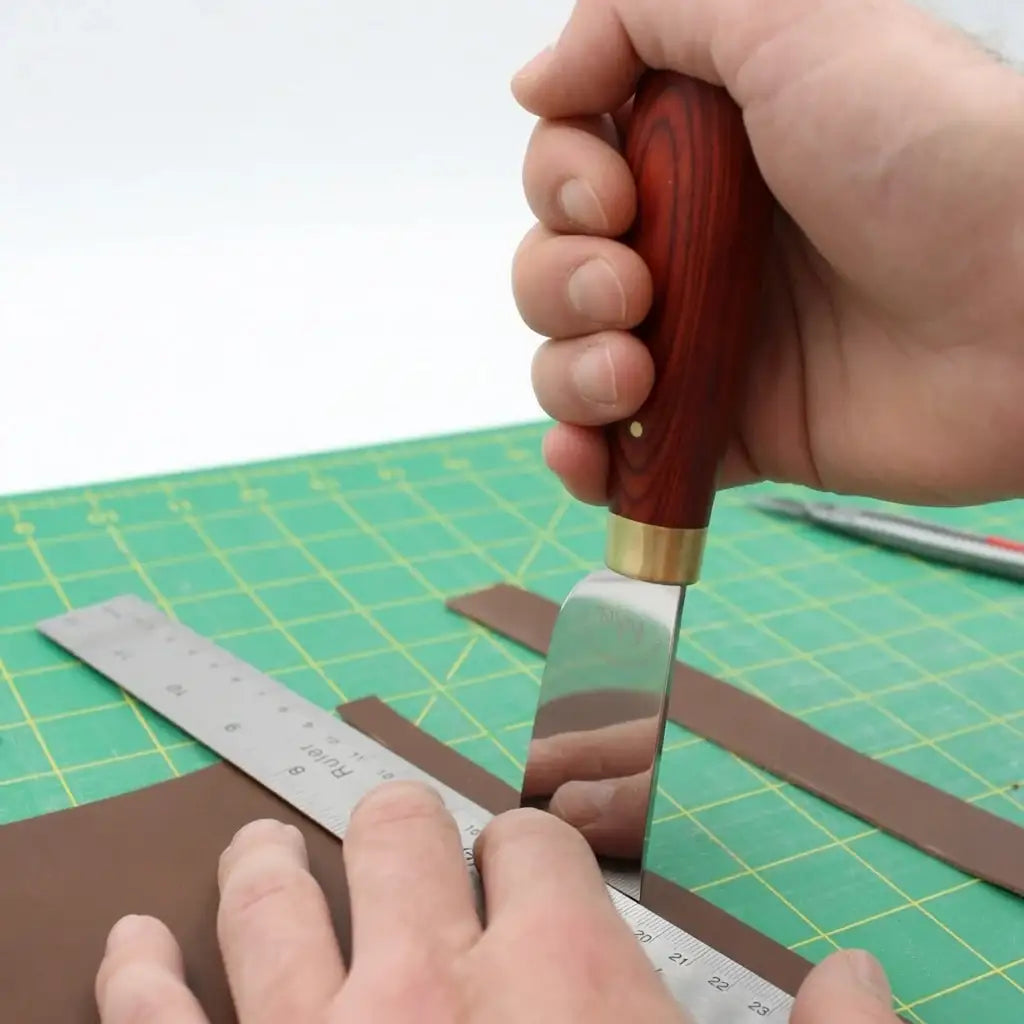 Leder schneiden mit Werkzeug auf grüner Schneidematte für Bastler und Handwerker