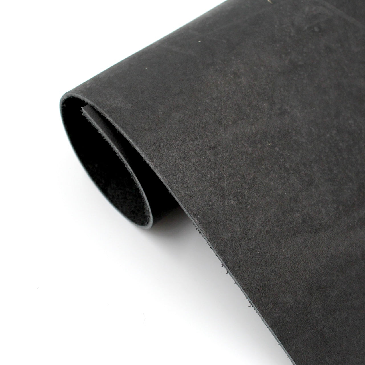Schwarzes Lederstück, halb eingerollt, samtartige Oberfläche, ideale Lederware zum Basteln