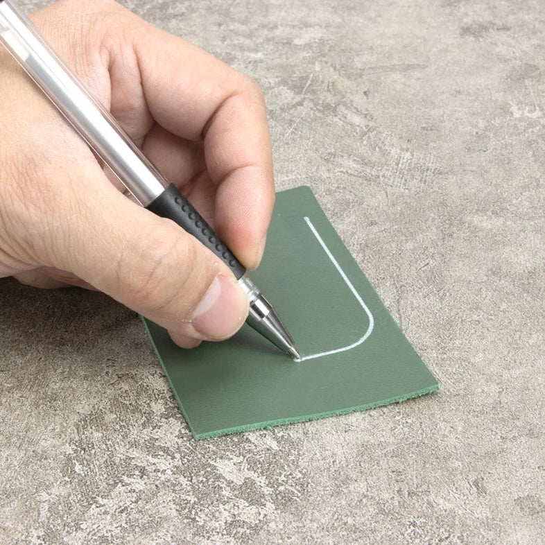 Hand benutzt einen Ivan Leathercraft Silberstift zum Markieren auf grünem Leder.
